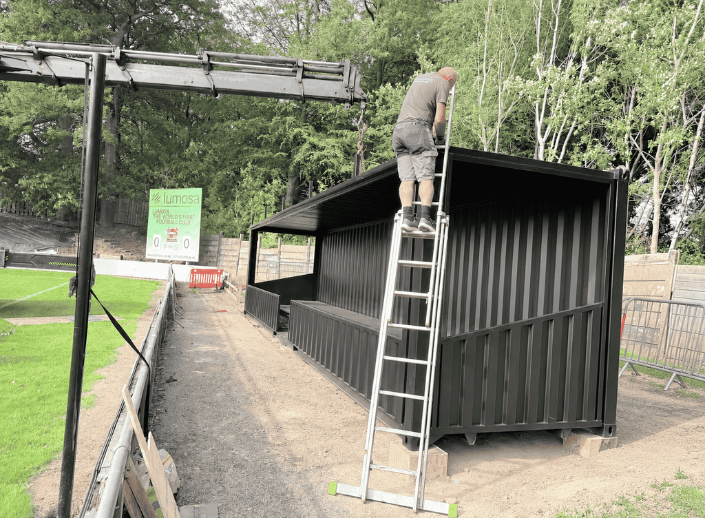 Final installation of the shipping container spectator stand at Sheffield FC stadium.