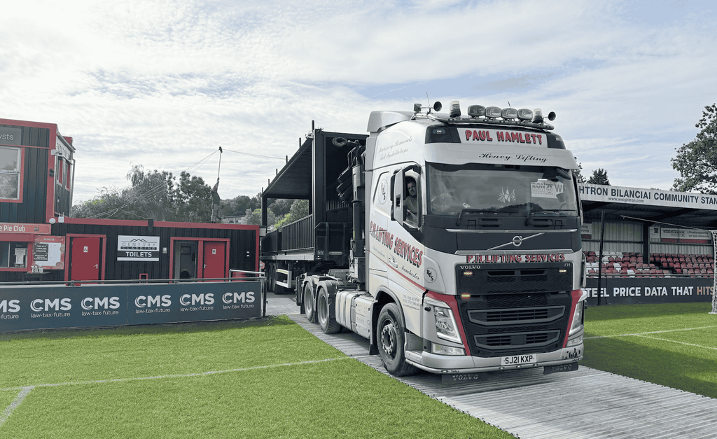 Shipping container spectator stand being delivered to Sheffield FC stadium on a lorry.