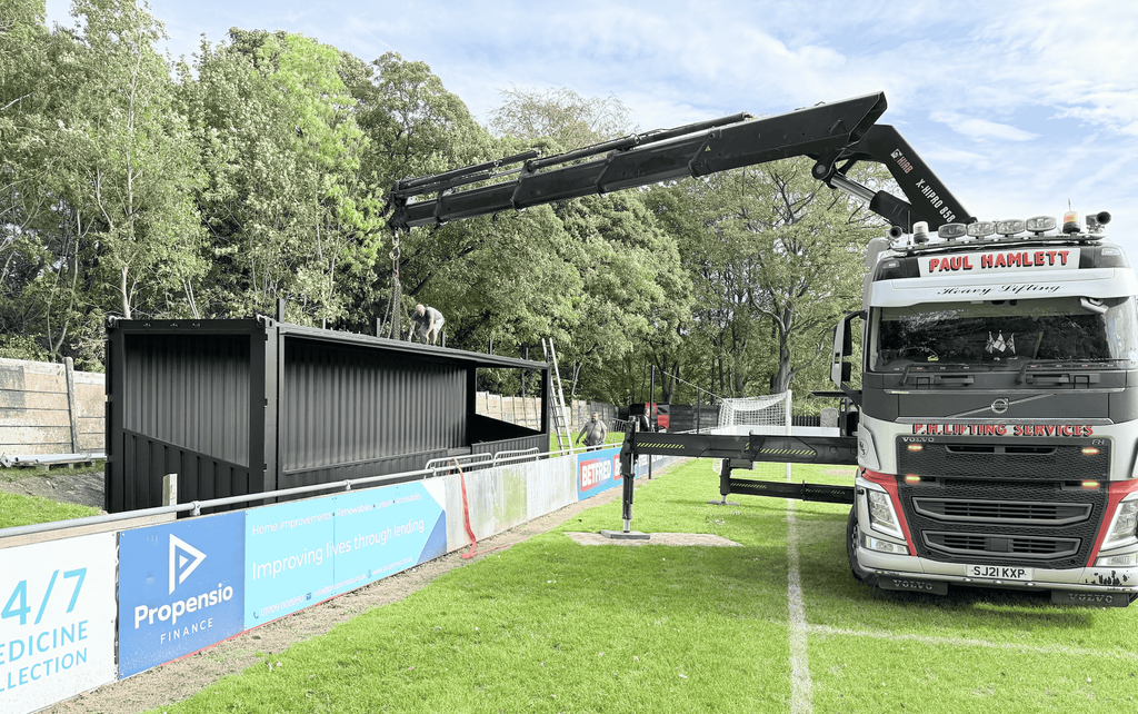 Shipping container spectator stand placed from a lorry at Sheffield FC stadium.